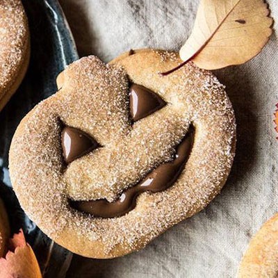 biscotti a forma di zucca di halloween ripieni di cioccolato decorati con zucchero e cannella