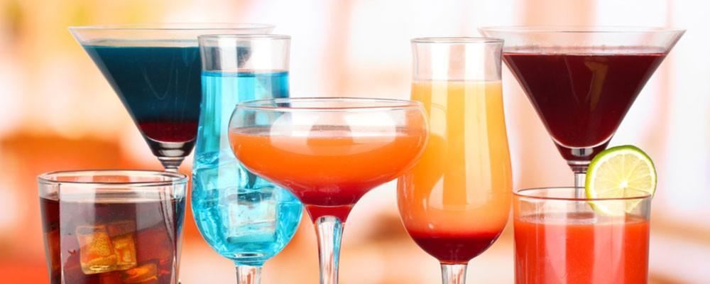 7 bicchieri diversi contenenti cocktails colorati